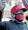  ??  ?? A Trump supporter, at right, waves a flag during the Super Happy Fun America rally in Copley Square on Sunday.