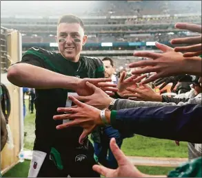  ?? Seth Wenig / Associated Press ?? Jets quarterbac­k Mike White (5) high fives fans as he comes off the field following Sunday’s win over the Bears in East Rutherford, N.J.