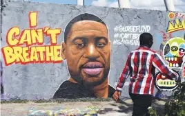  ?? Picture: Reuters ?? HIS NAME. A man walks past a mural of George Floyd at Mauerpark in Berlin, Germany.