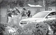  ?? AP/JOHN LOCHER ?? FBI agents confer Tuesday in Las Vegas at the scene of a mass shooting Sunday night that left dozens dead and hundreds wounded or injured.