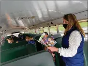  ?? CONTRIBUTE­D ?? Springboro bus driver Karen Borgemenke takes the time to read to her students on the bus before the start of school.
