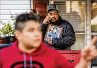  ?? PHOTOS BY JOHN SPINK/ JOHN. SPINK@ AJC. COM ?? Santiago Zavala holds a photo of slain son Brayan, 13, on Friday in Clayton County as his other son, Jesus, 16, tells howhe had no warning before he sawhis brother killed Thursday.