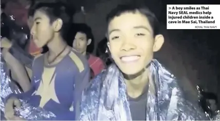  ?? ROYAL THAI NAVY ?? > A boy smiles as Thai Navy SEAL medics help injured children inside a cave in Mae Sai, Thailand