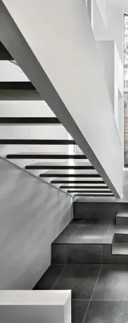 ??  ?? Above right Light permeates top to bottom through the open stairs, below which the attention to detail is evident in the perfectly lined-up tile joins Left Mario Scaffardi and Cindy Lagarde look up through the lightwell from the basement to the main...