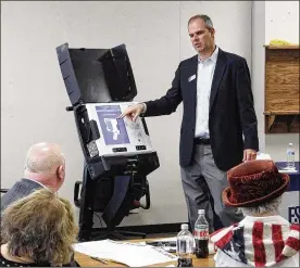  ?? TY GREENLEES / STAFF ?? Craig Seibert, regional sales manager, from Election Systems &amp; Software demonstrat­es a voting machine to the Greene County Board of Elections in Xenia. County Elections Director Llyn McCoy said they plan to decide this month on the type of voting machines they will purchase to have in place by November.