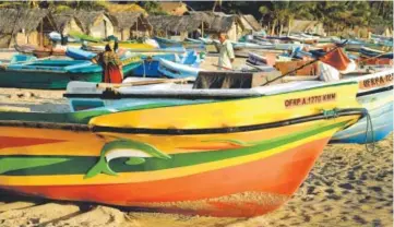  ??  ?? Top: Sunset over the bay at Passikudah, home to some of eastern Sri Lanka’s most luxurious beach hotels. Middle: An enormous statue of Shiva welcomes visitors to the Koneswaram temple complex, Trincomale­e. Bottom: Fishing boats line the beach in Arugam...