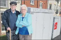  ??  ?? Rosemary and Donald Ferguson in their home with a box right outside their front window. Left, the couple standing by cabinets