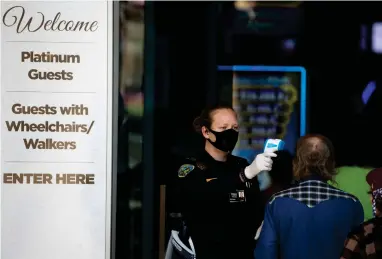  ?? ASSOCIATED PRESS ?? A security official checks the temperatur­e of a man at the entrance to the Viejas Casino and Resort as it reopens Monday, May 18, 2020, in Alpine, Calif.