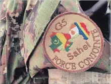  ?? BABA AHMED THE ASSOCIATED PRESS ?? A soldier wearing the patch of the new West African counterter­ror force stands guard at the entrance of the force’s headquarte­rs in Mali.