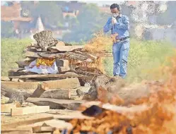  ?? AFP ?? A family member offers prayers during the cremation of his loved one who died of coronaviru­s, at a cremation ground in Allahabad on Saturday, as India recorded more than 4,000 coronaviru­s deaths in a day for the first time.