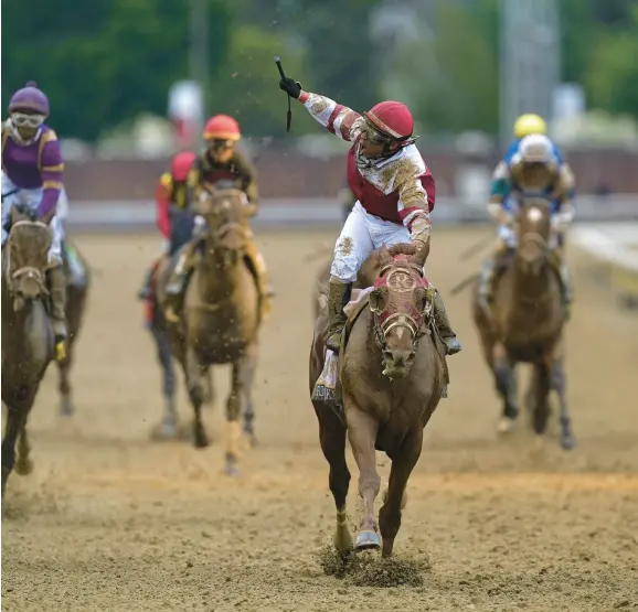  ?? AP PHOTO/CHARLIE NEIBERGALL ?? Sonny Leon celebrates after riding Rich Strike past the finish line to win the 148th running of the Kentucky Derby horse race at Churchill Downs Saturday, May 7, 2022, in Louisville, Ky.