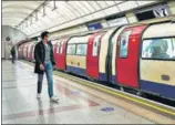  ?? AP ?? A passenger wearing a face mask walks along the undergroun­d train platform in London