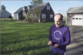  ?? H John Voorhees III / Hearst Connecticu­t Media ?? James Cunningham, of Redding, chooses the music he will listen to on his run Wednesday morning. Cunningham's wife started an effort to raise money for residents who might be struggling through the pandemic. She ran every day hoping that people would donate to the cause. When her knees gave out, her husband took over the running.