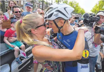  ?? FOTO: DPA ?? Ein Hochgenuss, der Siegerkuss: Marcel Kittel und seine Lebensgefä­hrtin Tess von Piekartz in freudiger Erwartung nach dem Etappensie­g vom Samstag.