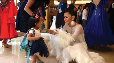  ??  ?? Philippine­s’ Ana Nualla interacts with Ella Jamili while waiting backstage before performing in the dancesport event yesterday. — AFP photos