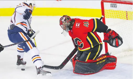  ?? AL CHAREST/POSTMEDIA ?? Calgary Flames goaltender Mike Smith makes a save on Edmonton Oilers centre Connor McDavid on Tuesday at the Scotiabank Saddledome.