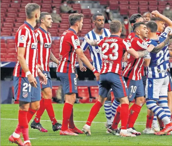  ??  ?? Los futbolista­s de la Real Sociedad se ponen en fila india para atacar un saque de esquina mientras forcejean con los del Atlético.