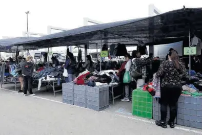  ?? ANDREEA VORNICU ?? Varias personas ojeando en uno de los puestos en el mercado ambulante de Zaragoza. =