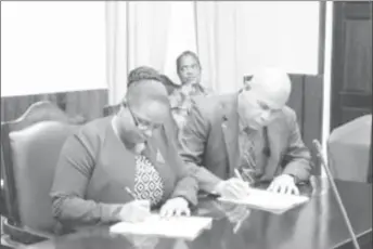  ?? (GINA photo) ?? Minister of Social Protection, Volda Lawrence (left) and Minister of Public Health, Dr. George Norton, signing the National Task Force for the Prevention of Sexual Violence protocol at Parliament Building