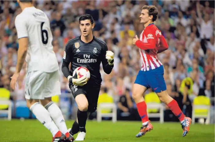  ??  ?? Thibaut Courtois celebra su tapada ante el francés Antoine Griezmann (der.), en una acción de peligro en la primera mitad. Minutos después le negaría el tanto a Diego Costa.