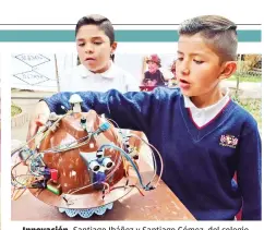  ??  ?? Innovación. Santiago Ibáñez y Santiago Gómez, del colegio Tiquipaya, explican cómo funciona el casco inteligent­e.