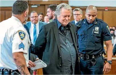  ?? AP ?? Former White House strategist Steve Bannon, centre, is escorted into the courtroom yesterday for his arraignmen­t in Manhattan State Supreme Court in New York.