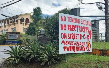  ?? SUZANNE VAN ATTEN / SVANATTEN@AJC.COM ?? A sign 20 miles south of San Juan, Puerto Rico, identifies a pocket of homes yet to have power restored five months after Hurricane Maria hit Sept. 20, 2017.