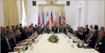  ?? THE ASSOCIATED PRESS ?? The European Union’s political director Helga Schmid and Iran’s deputy Foreign Minister Abbas Araghchi, center from left, wait for a bilateral meeting as part of the closed-door nuclear talks with Iran at a hotel in Vienna, Austria, Sunday.