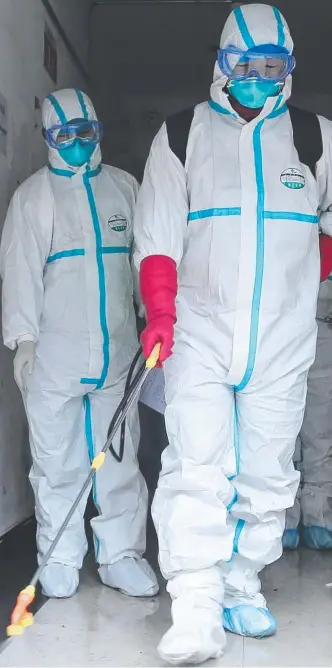  ?? Picture: STR/AFP ?? Workers disinfect a residentia­l area in Ruichang, near Hubei province. The global panic from the coronaviru­s in China spread to the Australian market yesterday.