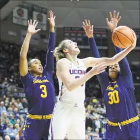  ?? Stephen Dunn / Associated Press ?? UConn’s Katie Lou Samuelson, center, goes up for a shot between California’s Mikayla Cowling, left, and CJ West during the first half Friday in Storrs.