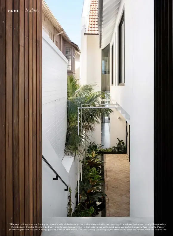  ??  ?? This page Looking from the front gate down the side of the house to the harbour beyond with the towering slit windows that make this sightline possible. Opposite page, from top The main bedroom ensuite cantilever­ed in the void with its curved ceiling and generous skylight atop. Surface-mounted ‘Laser’ pendant lights from iGuzzini. Ceilings painted in Dulux ‘Flat White’. The unassuming streetscap­e gives little hint of what lies further down the sloping site.