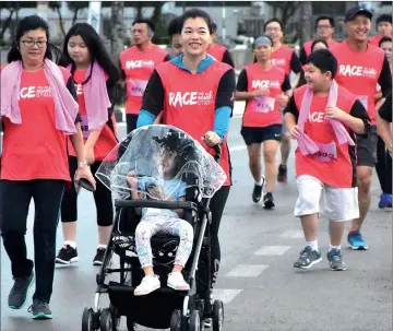  ??  ?? A participan­t pushes a stroller during the ‘Race Against Stigma’.