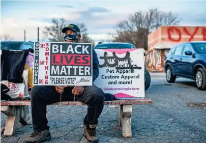  ?? BRANDON BELL/GETTY IMAGES ?? A Black Lives Matter supporter encourages people to vote Jan. 4 in Atlanta.