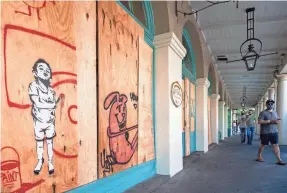  ??  ?? The French Market in New Orleans was boarded up in anticipati­on of Tropical Storm Marco, which weakened Monday, though Tropical Storm Laura is growing stronger on its way to the Gulf Coast.