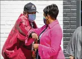  ?? CHRISTINA MATACOTTA FOR THE AJC ?? Mayor Keisha Lance Bottoms (right) elbow bumps an attendee at the ceremony to open the At-promise Center on Thursday.