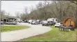  ??  ?? RVs fill the camping lot at Blowing Springs Park. The popular tiny cabin is on the right.