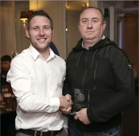  ??  ?? Alan King presents the Clubman of the Year award to Mark McGrogan on behalf of his son Glen McGrogan at the Enniskerry Youth Club awards at the Powerscour­t Arms recently.