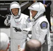  ?? JOHN RAOUX / AP ?? Storms threatened the launch site Wednesday, and the atmosphere was so electrical­ly charged that the spacecraft with NASA astronauts Doug Hurley (left) and Bob Behnken aboard could get hit by a bolt of lightning.