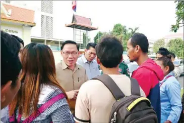  ?? SUPPLIED/PENG SREYSOR ?? Ministry of Rural Developmen­t official Yim Chung receives a recognitio­n petition from Chong representa­tives on Wednesday.