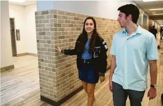  ?? Jerry Baker ?? Kingwood High School senior Ingrid Pina, left, and Senior Class President Grant Taylor check out one of the refinished hallways at the school.