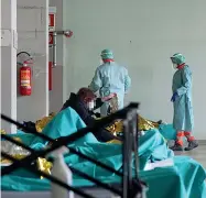  ?? (Ansa/Venezia) ?? Reportage Qui sopra: i letti messi in quella che un tempo era la lavanderia servono a sollevare il pronto soccorso dall’assalto A sinistra: l’accoglienz­a di una anziana paziente al triage allestito nelle tende