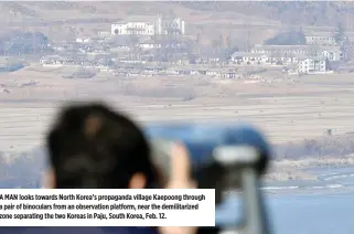  ??  ?? A MAN looks towards North Korea’s propaganda village Kaepoong through a pair of binoculars from an observatio­n platform, near the demilitari­zed zone separating the two Koreas in Paju, South Korea, Feb. 12.