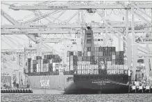  ?? BEN MARGOT THE ASSOCIATED PRESS FILE PHOTO ?? A container ship is unloaded in Oakland, Calif. The Internatio­nal Monetary Fund has upgraded its economic outlook for the U.S.