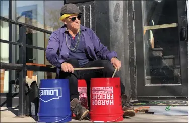  ?? DANA CADEY — STAFF WRITER ?? Longmont musician Perry Senn drums on buckets in the New Orleans jazz style outside of the Dickens Opera House, 302 Main St. The venue hosted its inaugural Mardi Gras celebratio­n on Saturday.