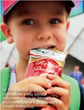  ??  ?? At the Spartak Stadium in Moscow, a boy tastes ice cream made by Mengniu, a Chinese brand that sponsors Russia World Cup