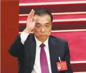  ?? AP PHOTO/NG HAN GUAN ?? Chinese Premier Li Keqiang raises his hand to vote in 2022 at the closing ceremony of the 20th National Congress of China’s ruling Communist Party at the Great Hall of the People in Beijing.