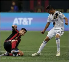  ??  ?? Atlanta United defender Franco Escobar (front left) slides to control the ball against Los Angeles Galaxy midfielder Joe Corona (14) in the first half of an MLS soccer game, on Saturday, in Atlanta. AP PHOTO/ANDREA SMITH