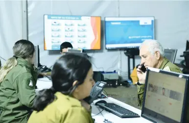  ?? (IDF) ?? IDF SOLDIERS man the phones at the National Assistance Center.