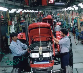  ??  ?? Mahindra factories are teeming with 200,000 employees; they build 300,000 tractors a year and are involved in aerospace, constructi­on, defence and automotive industries.