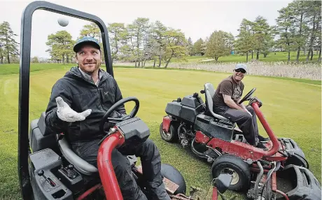  ?? CLIFFORD SKARSTEDT EXAMINER ?? Liftlock
Golf Club owner Brian Kruk tosses a golf ball in the air next to director of golf Barry MacIntyre while cutting grass at the course on Saturday. Golf courses got the green light from the province Friday to begin preparing for the new season, though the date they will be allowed to open was not specified.